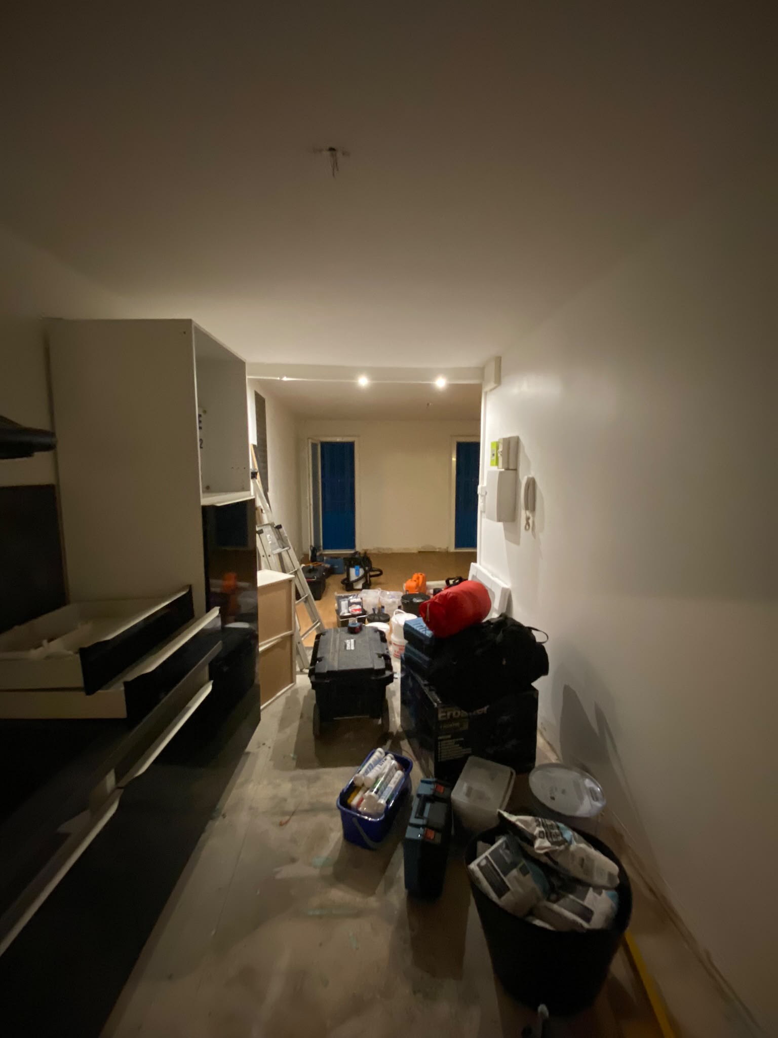 Cuisine pendant les travaux — meubles en cours d'installation, chape au sol, matériel de chantier