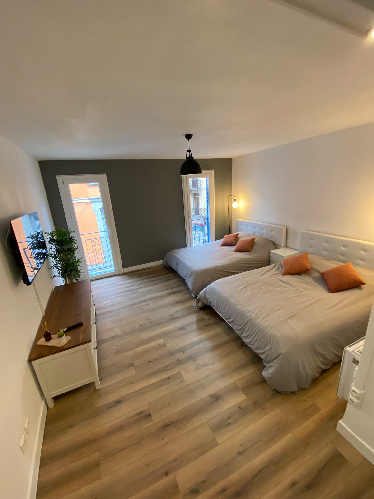 Chambre rénovée avec parquet chêne et mur d'accent — rénovation Alpes-Maritimes