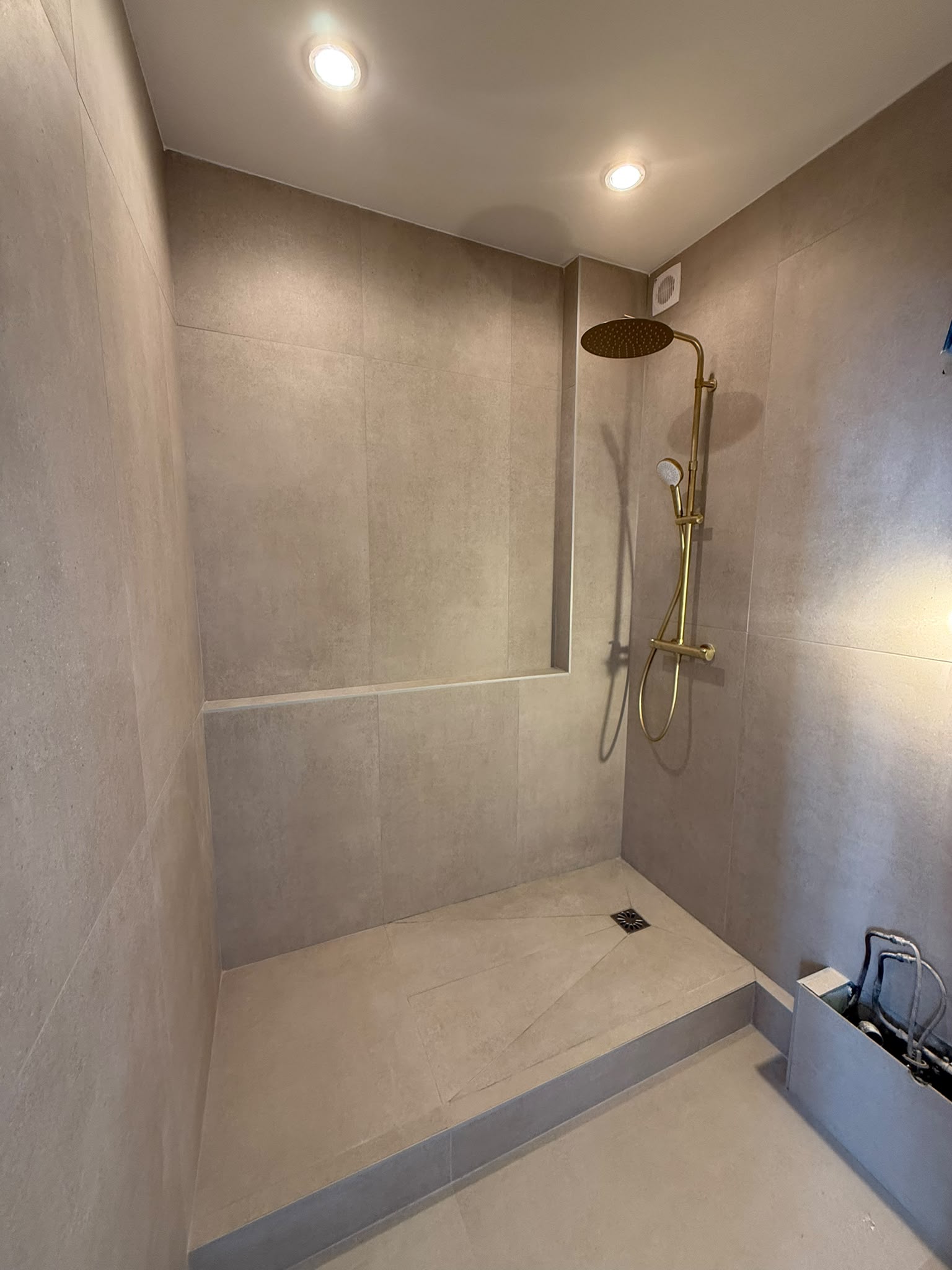Douche à l'italienne avec carrelage grand format et colonne dorée — Alpes-Maritimes
