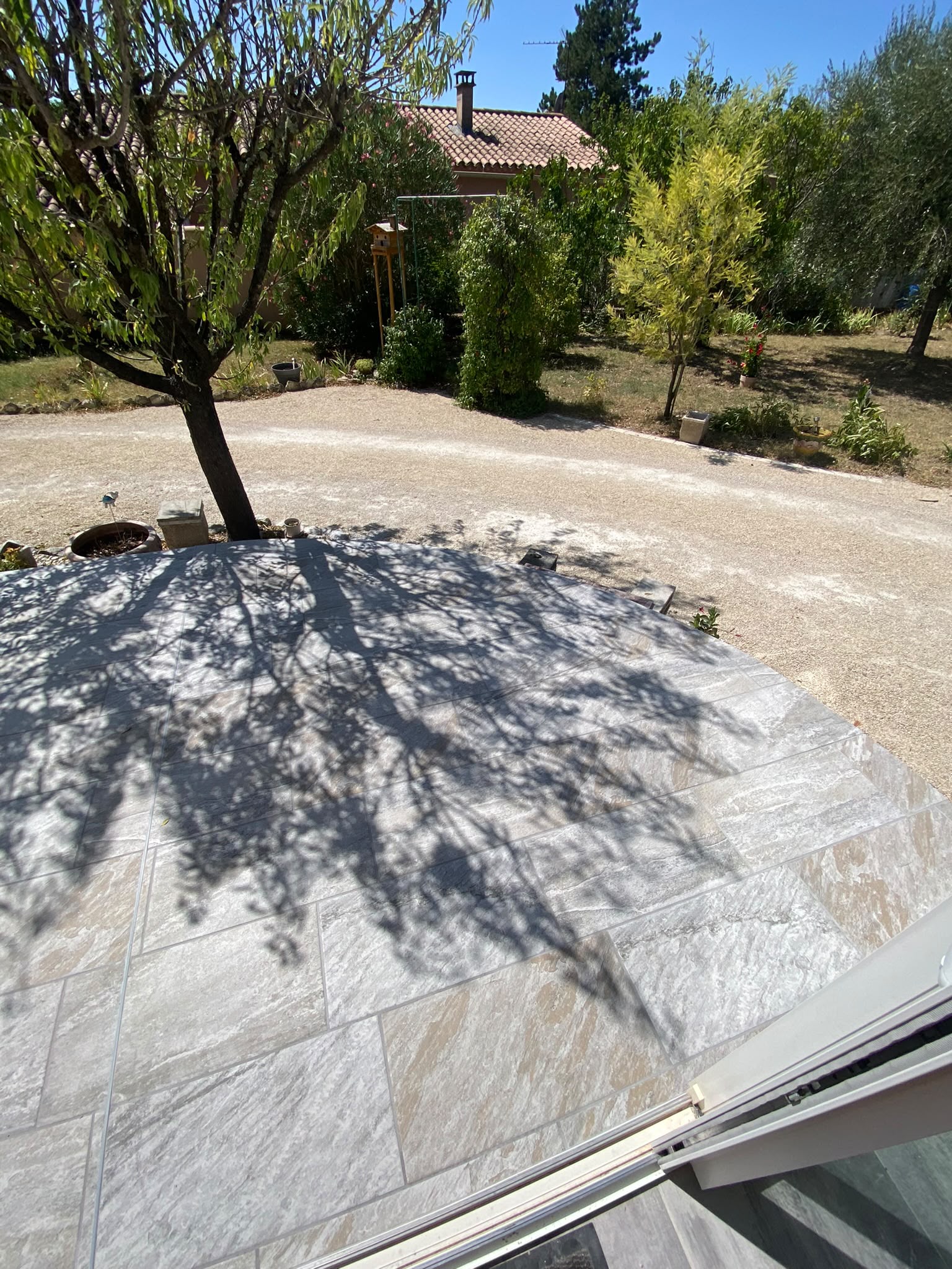 Terrasse carrelée effet pierre avec jardin méditerranéen